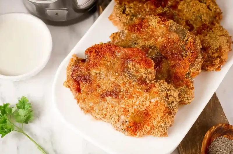 Golden, crispy Air Fryer chicken fried steak served on a white plate with creamy gravy on the side.