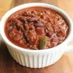 The Ultimate Wendy's Chili Recipe 5 Hearty bowl of homemade chili with ground beef, kidney beans, and green bell peppers, reminiscent of a delicious wendys chili recipe, served in a white ramekin.