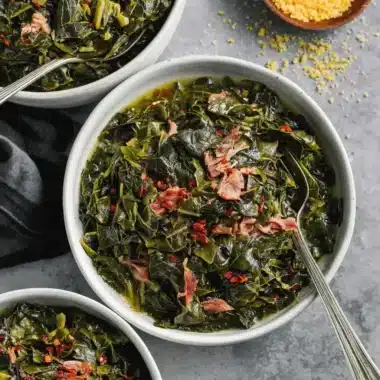 Overhead view of three white bowls filled with a flavorful, smoked meat-garnished collard greens recipe southern style.