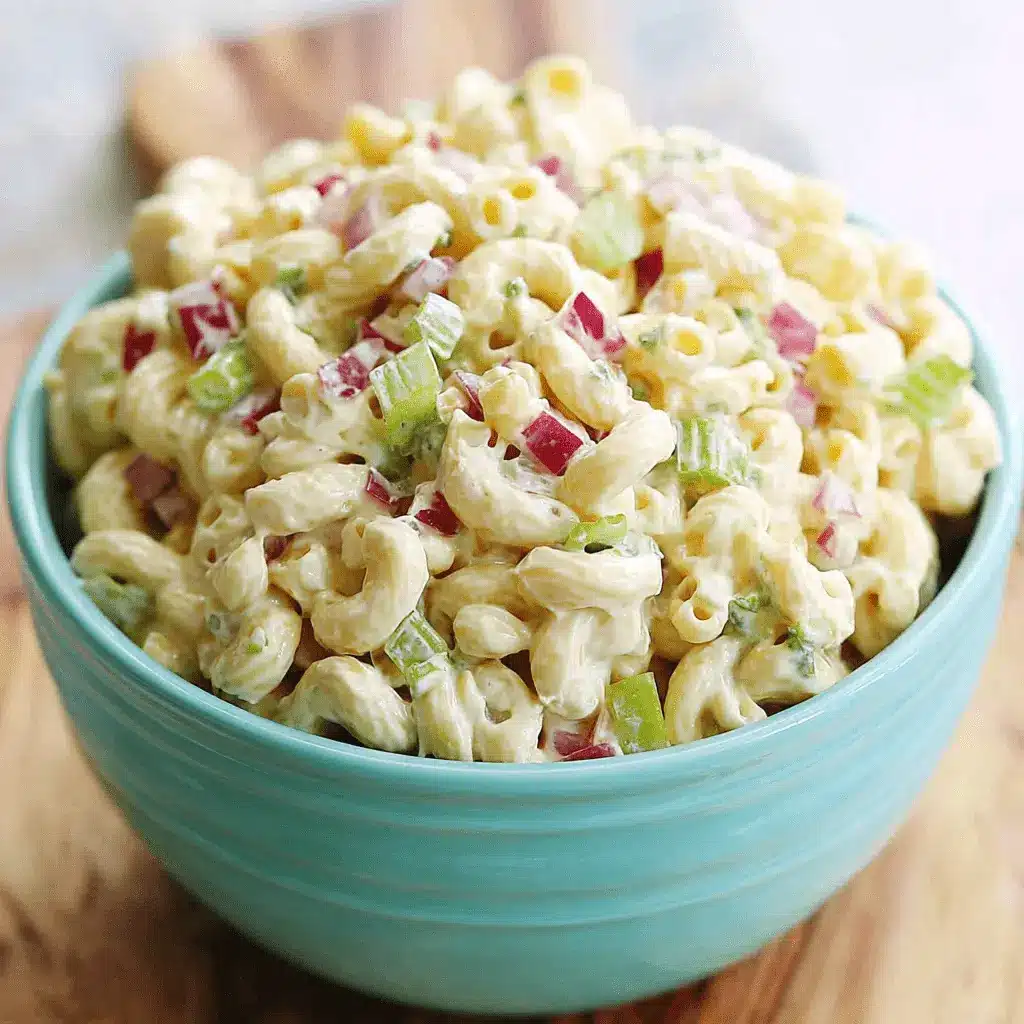 The Ultimate Foolproof Macaroni Salad Recipe 2 A generous bowl of creamy classic macaroni salad with celery and red onion, served in a bright aqua blue bowl.