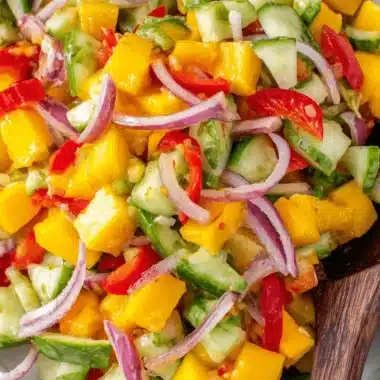 Ultimate Mango Salad Recipe: Vibrant & Refreshing 3 Close-up of a vibrant, chunky tropical mango salad with cucumber, red onion, and chili served in a rustic stoneware bowl.