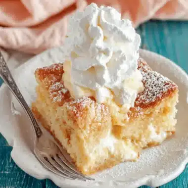 Amazing Foolproof Gooey Butter Cake Recipe 4 Slice of classic gooey butter cake dessert, featuring a creamy filling, powdered sugar dusting, and a scoop of vanilla ice cream.