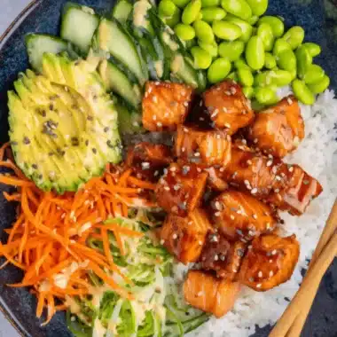 Amazing Salmon Rice Bowl for Quick Weeknights 3 Appetizing top-down view of a glazed salmon rice bowl featuring avocado, carrots, and edamame, ready to eat.