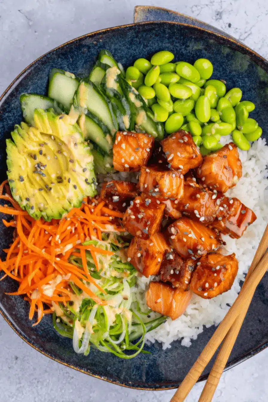 Amazing Salmon Rice Bowl for Quick Weeknights 2 Appetizing top-down view of a glazed salmon rice bowl featuring avocado, carrots, and edamame, ready to eat.