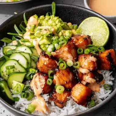 Foolproof Bang Bang Salmon: Quick & Flavorful Dinner 4 Overhead view of a delicious grilled chicken rice bowl with creamy orange sauce, avocado, and cucumber, inspired by the flavor profile of bang bang salmon.