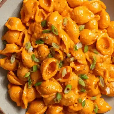 Ultimate Creamy Gochujang Pasta in 20 Minutes 4 Close-up of creamy shell Gochujang Pasta topped with sliced green onions in a rustic bowl.