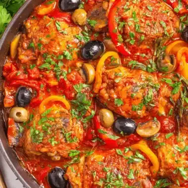 Ultimate Easy Chicken Cacciatore Recipe 4 Rustic cast-iron skillet filled with flavorful chicken cacciatore, featuring chicken pieces, tomatoes, bell peppers, and olives.
