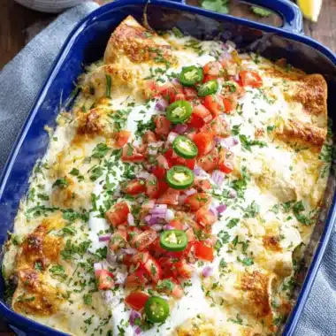 Amazing White Chicken Enchiladas: Quick & Creamy 4 Creamy white chicken enchiladas in a blue baking dish, garnished with pico de gallo, melted cheese, and fresh cilantro.
