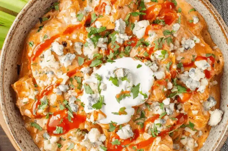 Overhead view of creamy Buffalo Chicken Dip with blue cheese crumbles and hot sauce, offering the intense flavor profile expected from buffalo chicken chili.