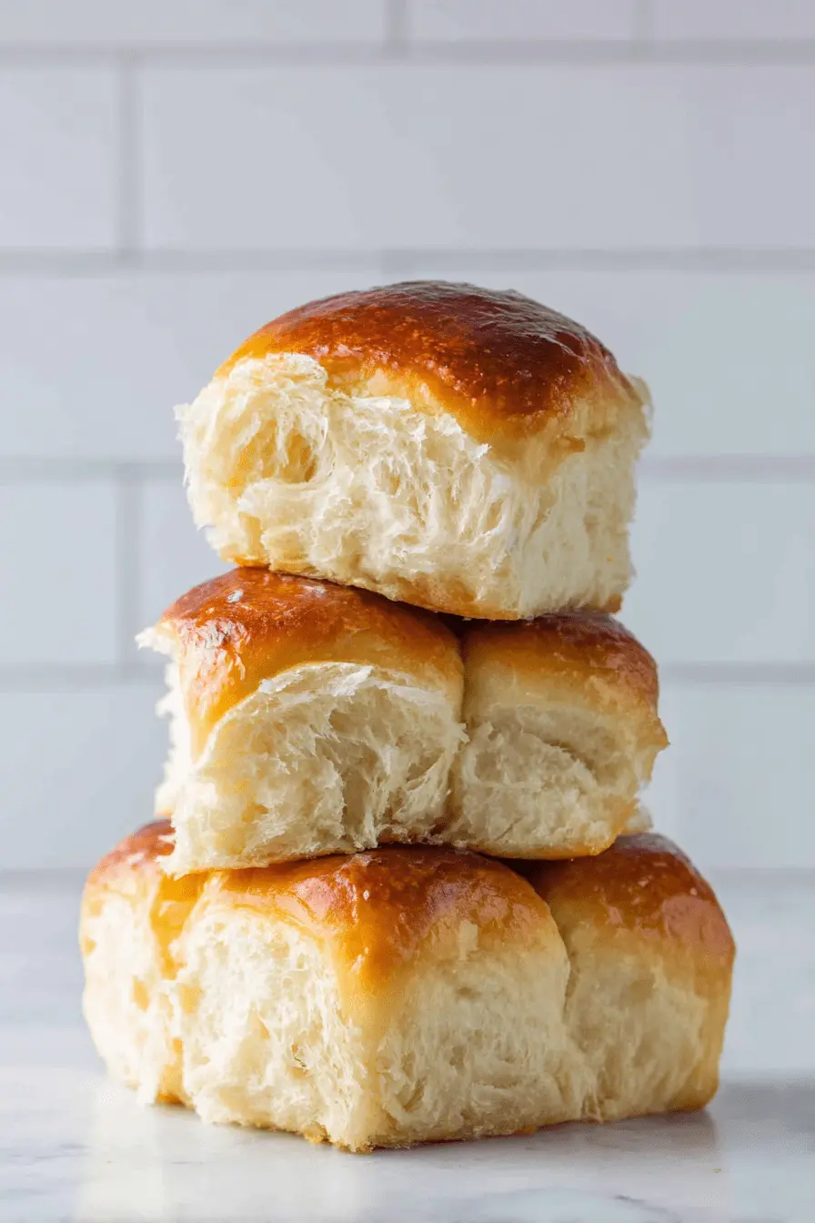 Ultimate Sourdough Hawaiian Rolls 2 Freshly baked stack of golden Sourdough Hawaiian Rolls showing a soft, airy crumb structure.
