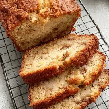 Foolproof Cottage Cheese Banana Bread 3 Overhead shot of sliced, moist cottage cheese banana bread with a crumb topping cooling on a black wire rack.