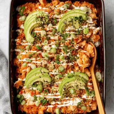 The Ultimate Salmon Sushi Bake Recipe for an Easy Feast 4 Top-down view of a colorful, layered salmon sushi bake recipe in a blue dish, garnished with avocado and ready for serving.