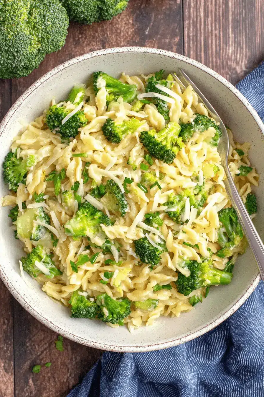 Ultimate One-Pot Broccoli Cheddar Orzo 2 Close-up of a comforting bowl of creamy broccoli cheddar orzo sprinkled with fresh herbs.