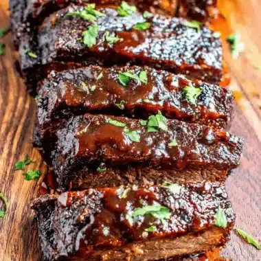 Ultimate Slow Cooker Beef Brisket Recipe 4 Overhead shot of deeply sauced, sliced beef on a rustic cutting board, showcasing the tenderness achieved by a perfect slow cooker beef brisket recipe.