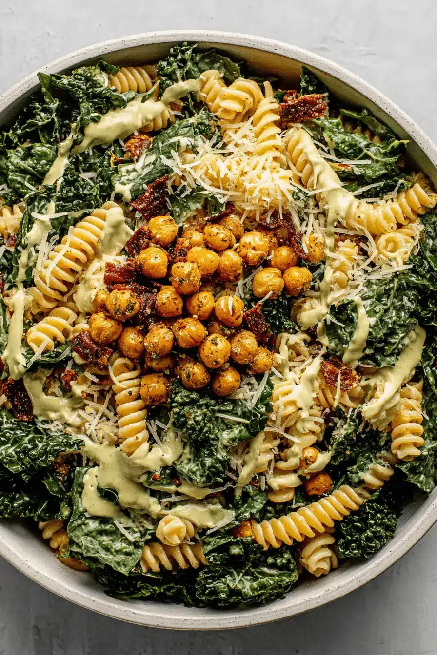 Quick & Easy Kale Pasta Caesar Salad 2 Generous serving of vibrant kale pasta caesar salad featuring rotini, roasted chickpeas, and a creamy dressing.