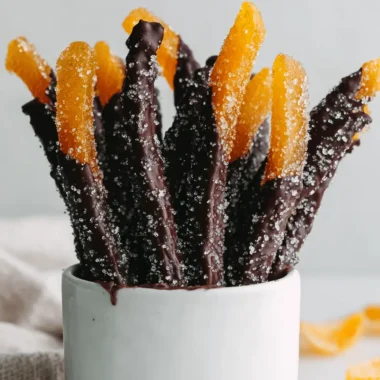 Amazing Homemade Chocolate Covered Orange Peel 4 Artful display of gourmet chocolate covered orange peel strips standing upright in a white ceramic cup.