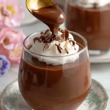 Sensational Homemade Chocolate Pudding 3 Rich, decadent chocolate pudding dessert in a clear glass with whipped cream and dark chocolate shavings.