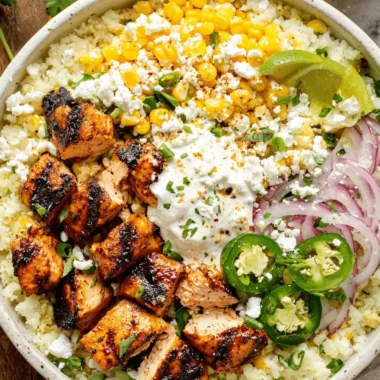 Amazing Street Corn Chicken Rice Bowl Recipe 3 Vibrant street corn chicken rice bowl with grilled chicken, creamy sauce, cotija cheese, and fresh lime wedges.
