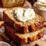 Amazing Sour Cream Banana Bread Recipe 7 Delicious slices of moist sour cream banana bread with creamy butter on a rustic cutting board.