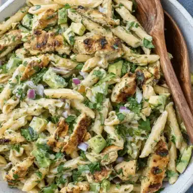 Amazing Chicken Pasta Salad: Your New Go-To Meal 3 Creamy chicken pasta salad with penne, avocado, and grilled chicken in a speckled ceramic bowl.