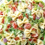 Ultimate BLT Pasta Salad: A Simple Weeknight Win 7 Close-up of a vibrant blt pasta salad with farfalle, crispy bacon, fresh lettuce, cherry tomatoes, and red onion in a glass bowl.