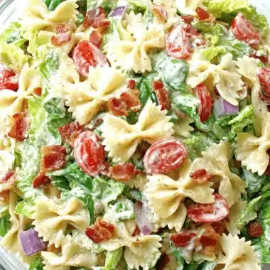 Ultimate BLT Pasta Salad: A Simple Weeknight Win 4 Close-up of a vibrant blt pasta salad with farfalle, crispy bacon, fresh lettuce, cherry tomatoes, and red onion in a glass bowl.