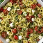Thrilling Bow Tie Pasta Salad: Quick & Flavorful 5 Close-up of a vibrant bow tie pasta salad with pesto, cherry tomatoes, and mozzarella.