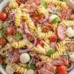 The Ultimate Italian Grinder Pasta Salad 5 Vibrant Italian grinder pasta salad with rotini, salami, prosciutto, mozzarella, tomatoes, and basil.