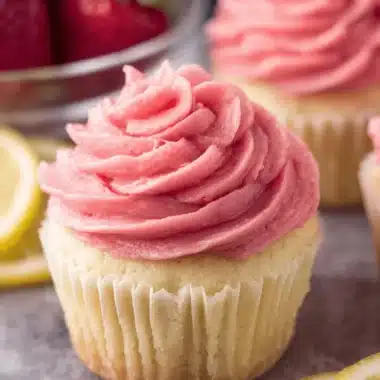 Sensational Strawberry Lemonade Cupcakes 3 Close-up of a single, perfectly swirled pink-frosted golden cupcake, emphasizing the delicious **Strawberry Lemonade Cupcakes**.