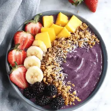 Ultimate Acai Bowl Recipe: Thick, Creamy, & Easy 3 Overhead view of a vibrant acai bowl topped with fresh strawberries, bananas, mango, and granola, illustrating a delicious acai bowl recipe.