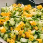 Vibrant Mango Cucumber Salad: Easy & Refreshing 6 Vibrant close-up of a refreshing mango cucumber salad garnished with sesame seeds and fresh herbs in a ceramic bowl.