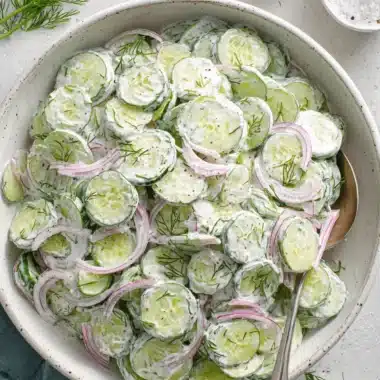 Amazing Creamy Cucumber Salad Recipe 4 Creamy Cucumber Salad in a rustic ceramic bowl, garnished with fresh dill, red onion, and a hint of red pepper flakes.