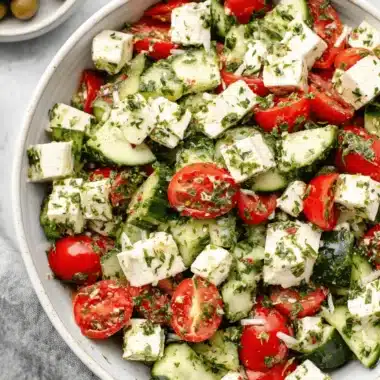 Vibrant Cucumber Feta Salad: Quick & Easy 3 Close-up, overhead shot of a fresh and vibrant Cucumber Feta Salad in a light bowl, featuring cherry tomatoes and a herby dressing.