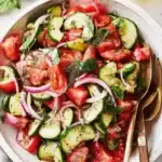 Vibrant Cucumber Tomato Salad: Easy Summer Side 7 Overhead close-up of a fresh, vibrant cucumber tomato salad served in a rustic ceramic bowl, garnished with dill and basil.