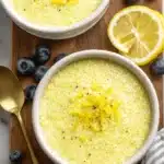 Vibrant Lemon Chia Seed Pudding: Quick & Easy Recipe 6 Two servings of creamy lemon chia seed pudding garnished with zest and fresh blueberries on a rustic wooden cutting board.