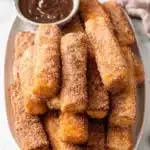 Foolproof French Toast Sticks: Easy & Delicious 7 Golden, crispy churro bites dusted with cinnamon sugar and served with chocolate sauce, a delicious alternative to French Toast Sticks.
