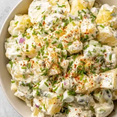 Foolproof Creamy Potato Salad with Egg 4 Creamy, homemade potato salad with egg, garnished with fresh chives and paprika in a light bowl.