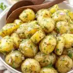 Vibrant French Potato Salad: Quick & Easy Recipe 5 Close-up of rustic French potato salad with waxy potatoes, fresh dill, and red onion in a light bowl with wooden spoons.