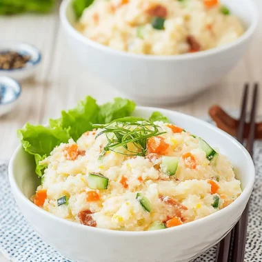 The Ultimate Japanese Potato Salad Recipe 4 Creamy Japanese potato salad with carrots, cucumber, and chives, served in a white bowl with chopsticks.