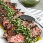 The Ultimate Chimichurri Skirt Steak Recipe 5 Perfectly grilled and sliced chimichurri skirt steak on a white plate.