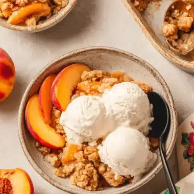 Magic Peach Cobbler with Fresh Peaches 4 Delectable peach cobbler with fresh peaches, served in rustic bowls with melting ice cream.