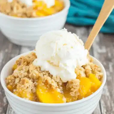 Amazing Crockpot Peach Cobbler: Easy Dessert 4 Close-up of a delectable crockpot peach cobbler with a golden-brown topping and melting vanilla ice cream.