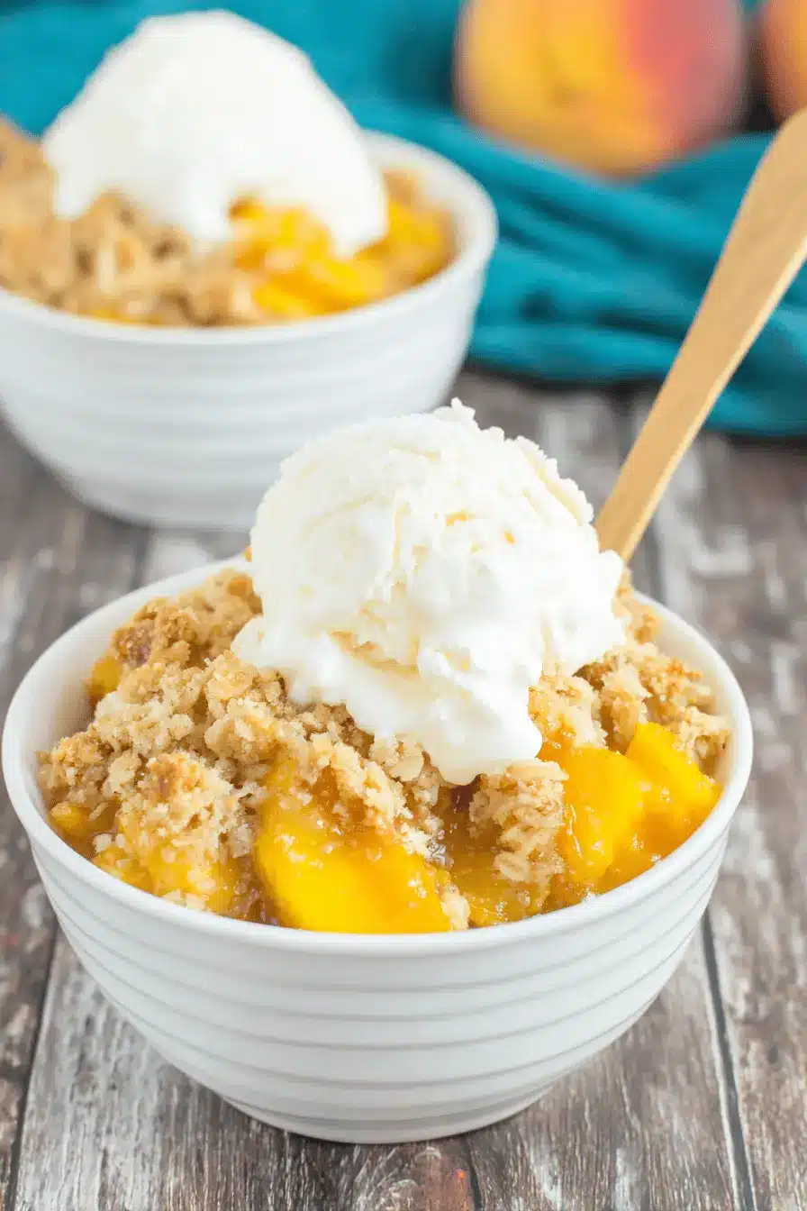 Amazing Crockpot Peach Cobbler: Easy Dessert 2 Close-up of a delectable crockpot peach cobbler with a golden-brown topping and melting vanilla ice cream.