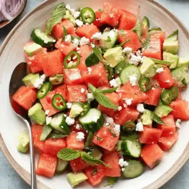 The Ultimate Watermelon Feta Salad Recipe 15 Vibrant watermelon feta salad with mint, avocado, cucumber, and jalapeño in a ceramic bowl.