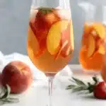 Fantastic Easy Non-Alcoholic Peach Sangria Recipe 5 Refreshing peach sangria with strawberries in a glass, perfect for a summer peach sangria recipe.