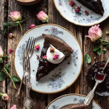 Amazing Chocolate Cherry Desserts: Easy Bars Recipe 3 Decadent chocolate cherry desserts, featuring rich chocolate cake with whipped cream, fresh cherries, and rose petals on antique plates.