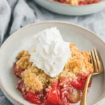Amazing Rhubarb Dump Cake: Easy & Foolproof 5 Delectable rhubarb dump cake with whipped cream in a ceramic bowl.