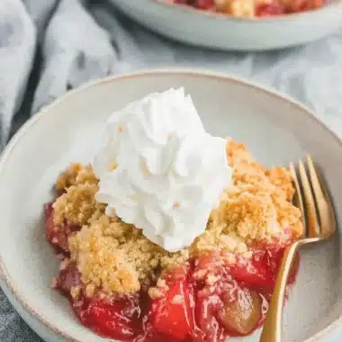 Amazing Rhubarb Dump Cake: Easy & Foolproof 3 Delectable rhubarb dump cake with whipped cream in a ceramic bowl.