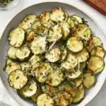 Ultimate Crispy Roasted Zucchini Recipe 7 Close-up of perfectly roasted zucchini slices with melted Parmesan and fresh herbs.