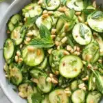 Easy & Vibrant Zucchini Salad Recipe 7 Overhead view of a vibrant zucchini salad with mint, peanuts, and green onions in a gray ceramic bowl.